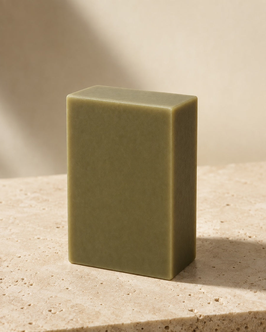 The Bamboo Mud bar, muted olive green, standing on a travertine ledge